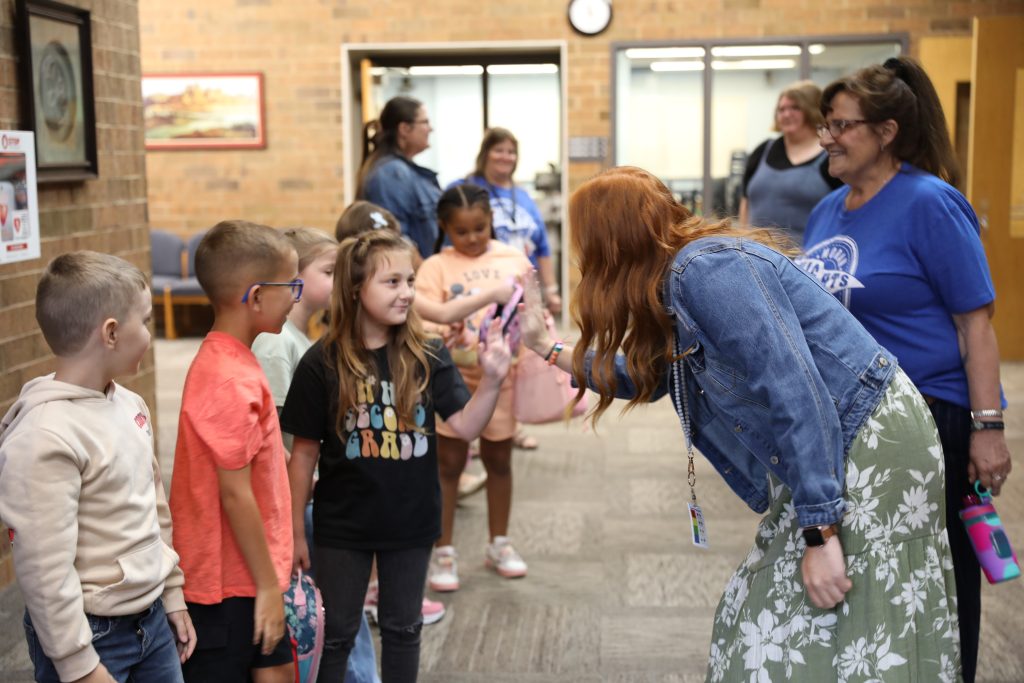 teacher gives student a high five