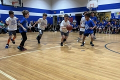 Children playing basketball in gymnasium.
