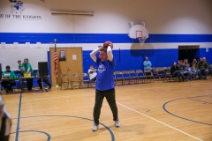 Woman in blue shirt playing basketball on court.