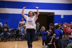 Woman in white shirt celebrating on basketball court.