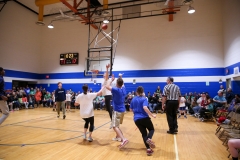 People playing basketball in a gymnasium.