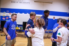 A group of people celebrating in a gymnasium.