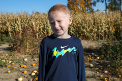 Young boy posing in a cornfield.