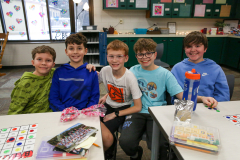 Five students posing in a classroom for a picture on Valentine's Day.
