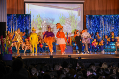 A group of people, some dressed as characters from the movie "Finding Nemo," on stage performing.