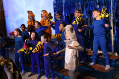 Children in costumes performing on stage.