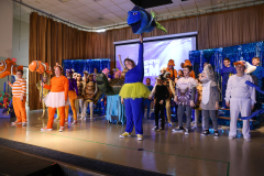 A group of people dressed in colorful costumes performing Finding Nemo
