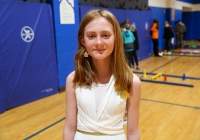 Young girl in a gymnasium, posing for a picture.
