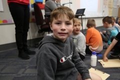 Boy sitting in front of group of children.