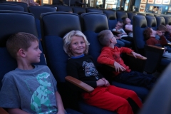 Children in a movie theater watching a movie together.