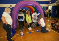People gathered around a colorful inflatable tunnel, possibly for an event or celebration.
