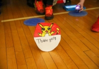 Thanksgiving celebration in a gymnasium with a small Pokémon-themed paper lantern.
