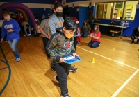 Children playing with sphero robots in a gymnasium.