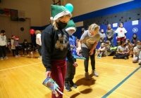 Children in a gymnasium dressed as elves for Christmas party.