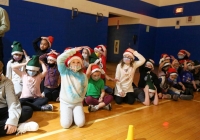 Children in Santa hats posing for a picture on a basketball court.